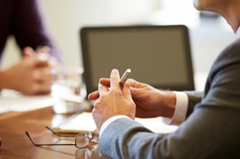 Financial Avisors hands on a conference table